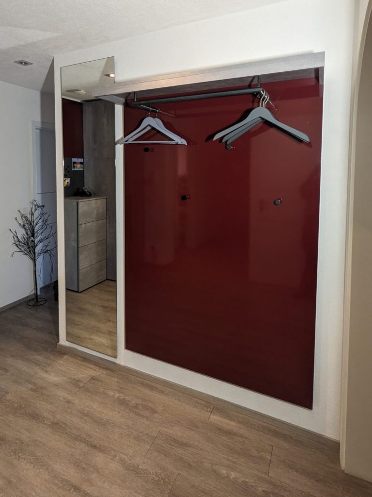 Einfache Garderobe in Rot, mit Spiegel und Kleiderstange